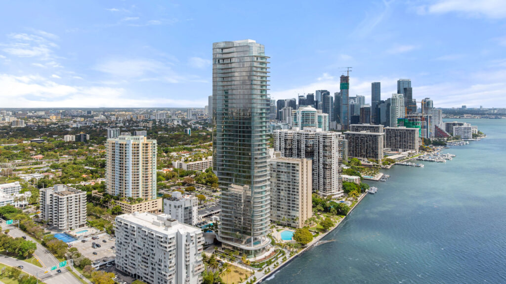 Aerial drone photography of a luxury high-rise tower in Edgewater Miami with Biscayne Bay and downtown skyline in the background — drone real estate photography